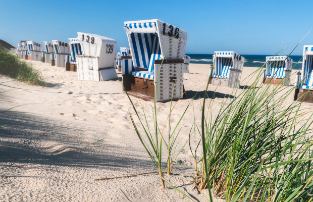 Strand in Sylt mit Strandkörben - hier vermietet C - A Sylt Ferienwohnung und nutzt die KI-Telefonassistentin Frag Maxi.